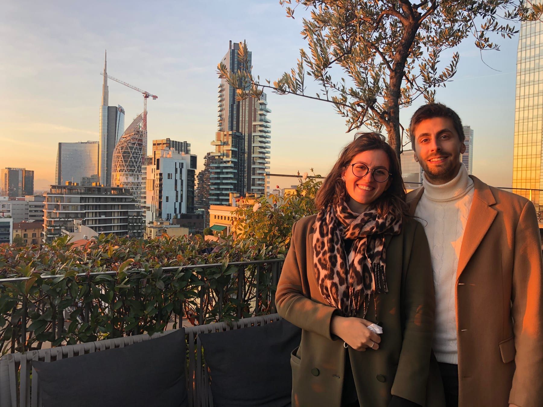 Giorgia and Jacopo on a rooftop at sunset, with the Porta Nuova skyline behind them