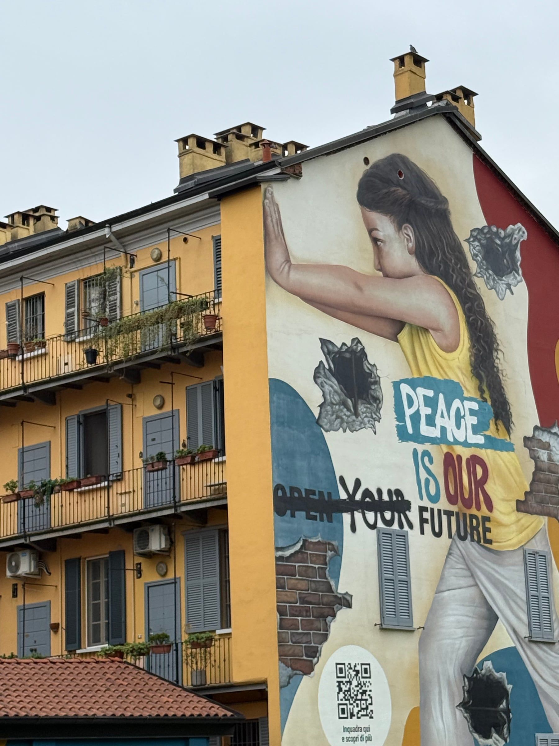 A mural painted on the blank wall of an old balcony house in Isola
